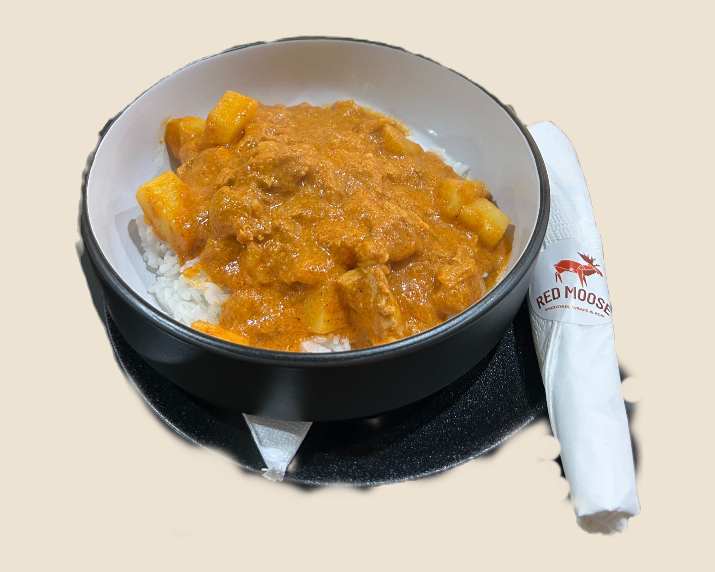 Butter chicken on rice in a black bowl