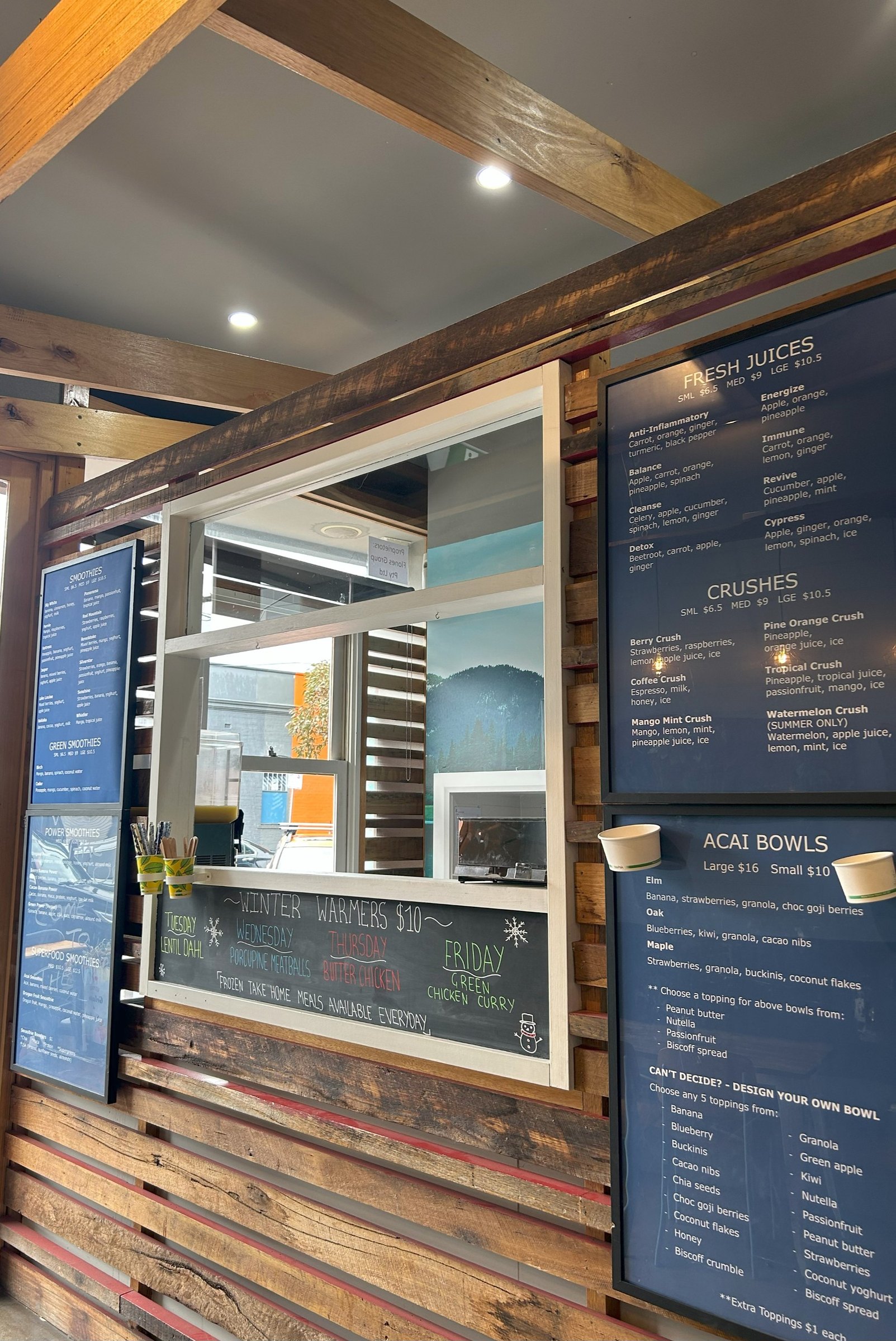 Timber counter with the smoothie, juice and acai menu boards