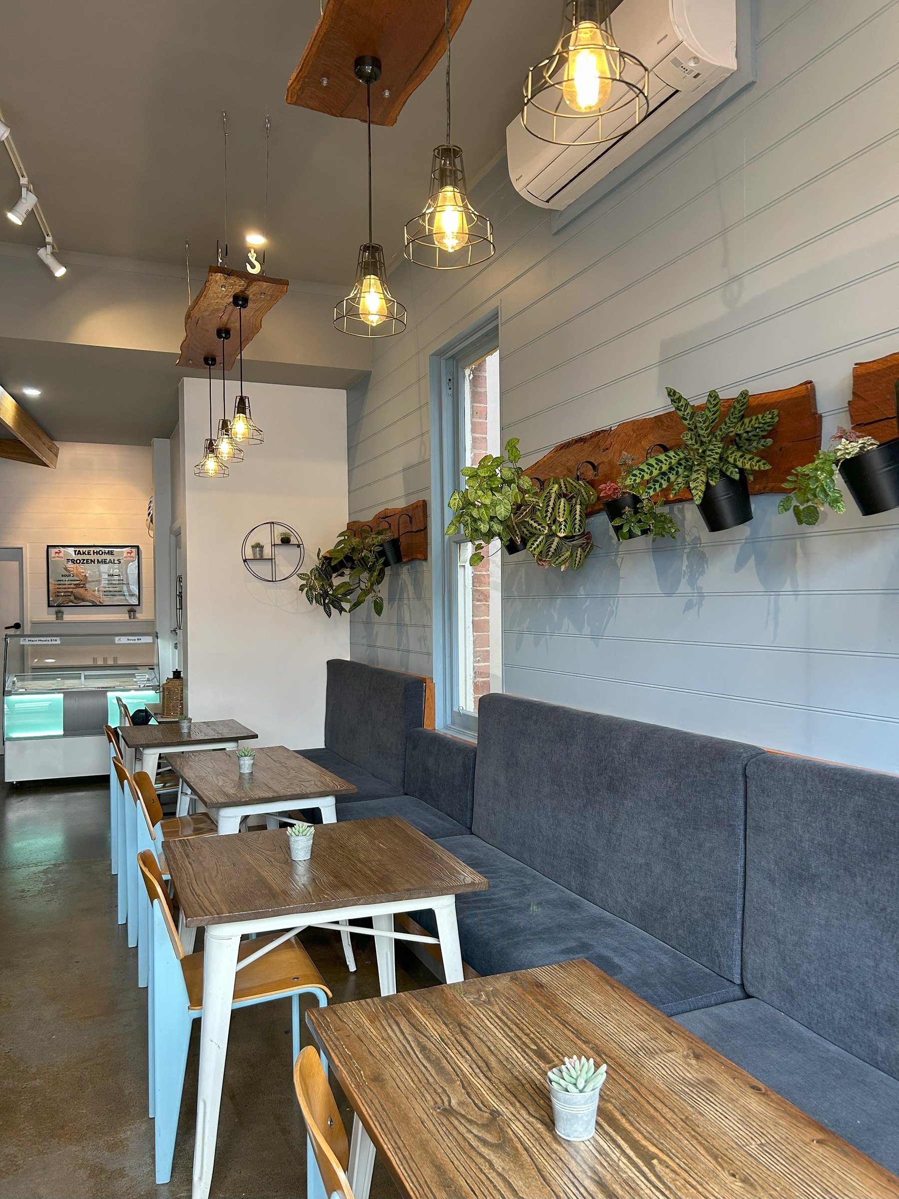 Timber tables and a long bench under hanging plants
